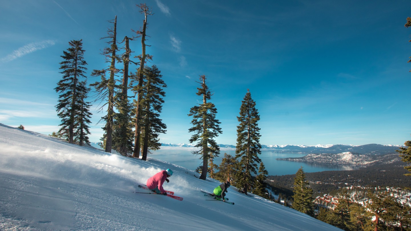 2 skiers turning on a groomer