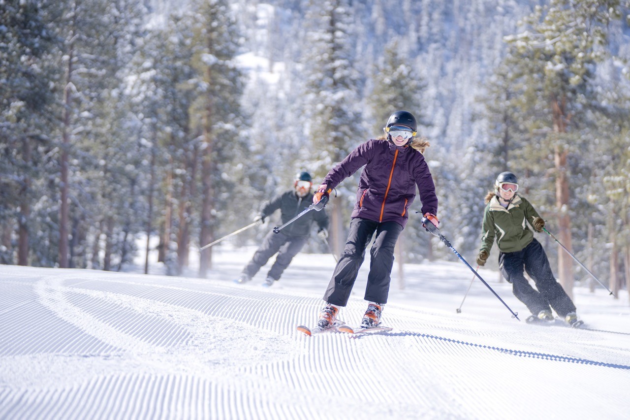 Skiers on a groomer